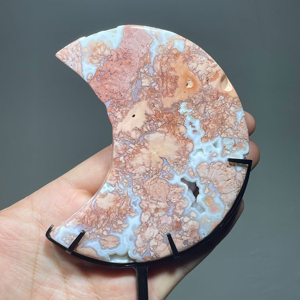 Closeup of a pink and blue Cotton Candy Agate moon carving showing its botryoidal patterns