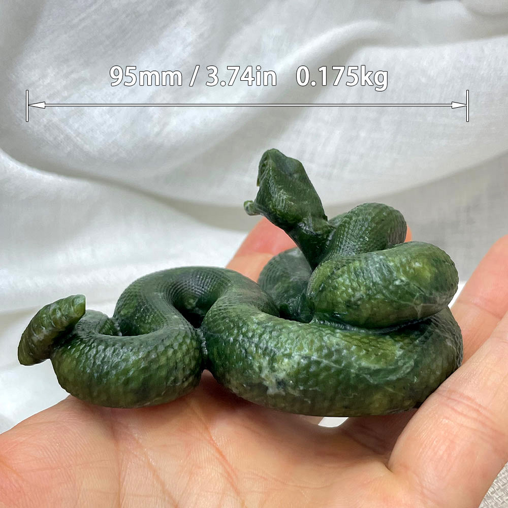 Side profile of a coiled green serpentine snake carving held in a hand to show its size