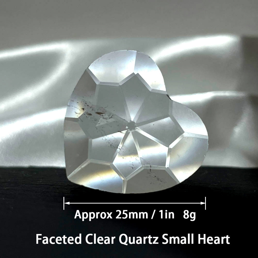 A clear quartz faceted heart showing its approximate size of 25mm or 1 inch