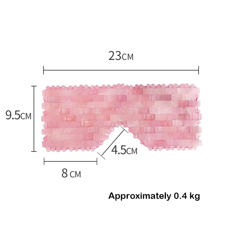 A pink rose quartz eye mask showing its dimensions in centimeters