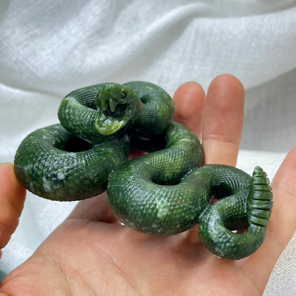 Front view of a hand-carved serpentine rattlesnake statue with an open mouth