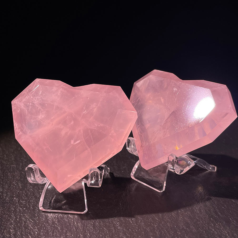 Two hand-carved faceted rose quartz hearts displayed side-by-side