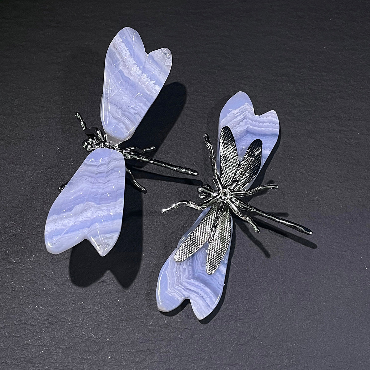 Two blue lace agate dragonfly figurines with silver-toned bodies shown side-by-side.