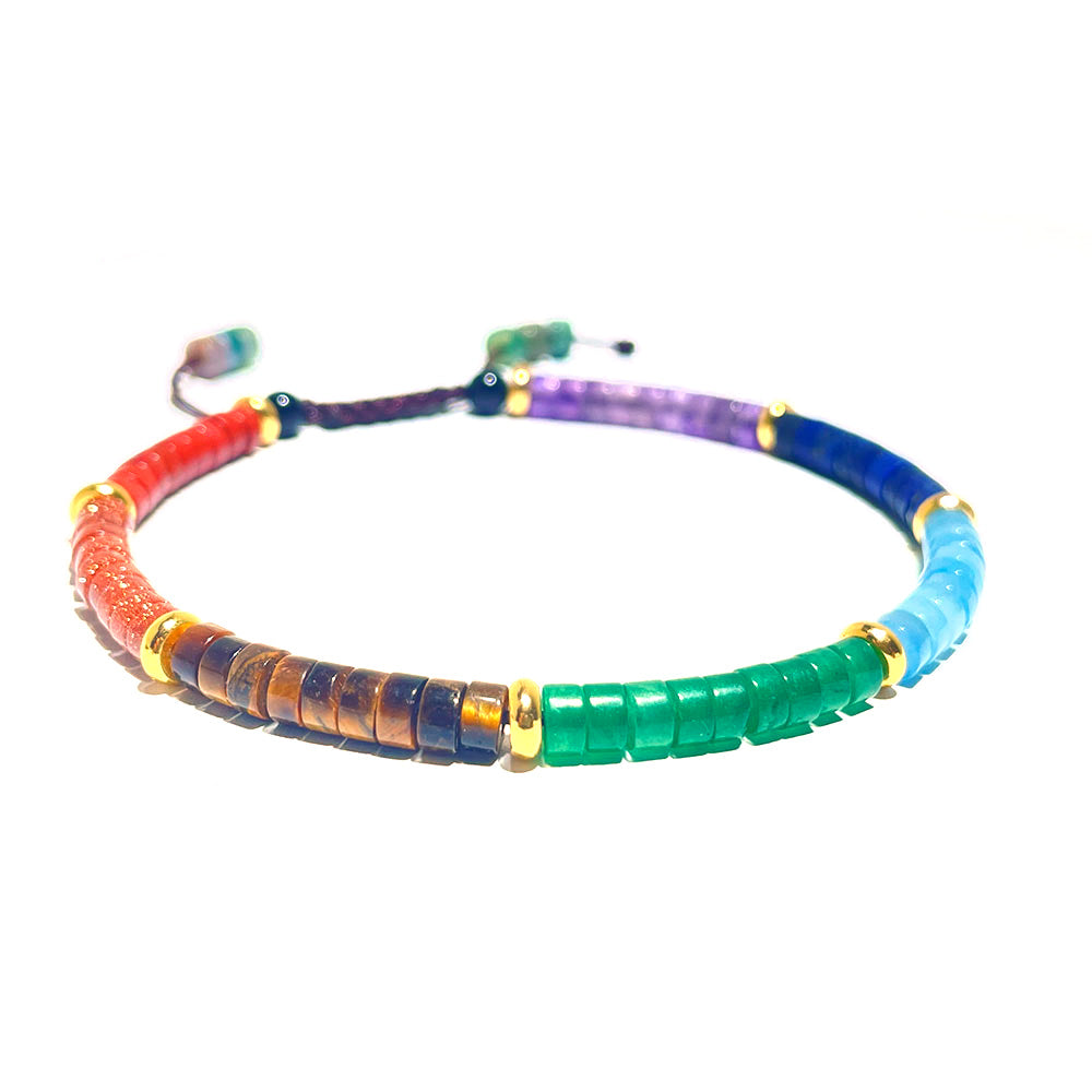 A close-up of an adjustable 7 chakra heishi bead bracelet on a white background