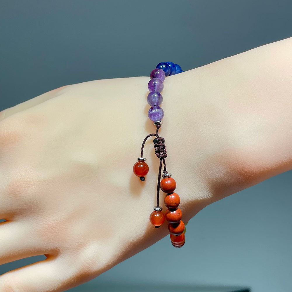 The back of a wrist showing the adjustable knot clasp of a 7 chakra bracelet.