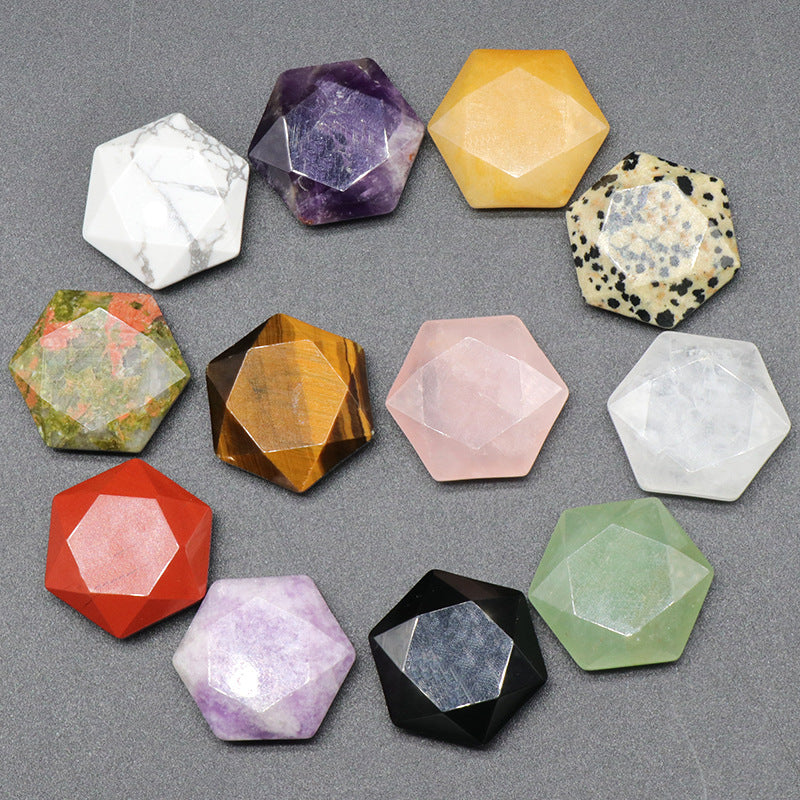 A collection of twelve assorted faceted crystal hexagons on a grey background.