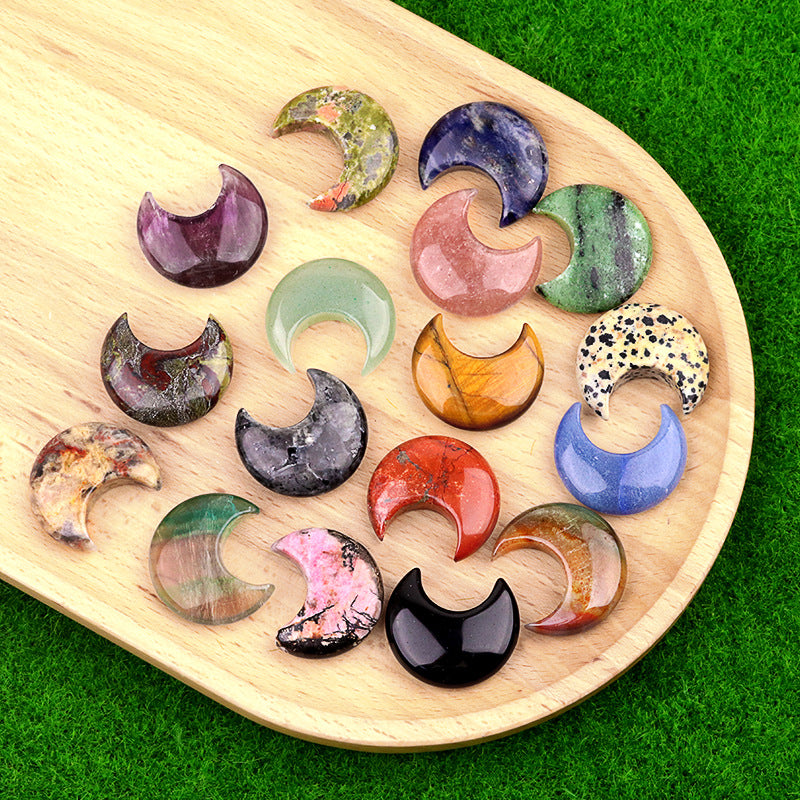 A collection of colorful, polished gemstone crescent moons displayed on a wooden tray.