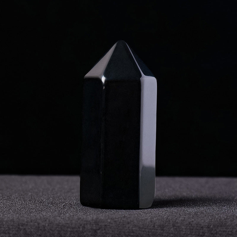 A sleek, polished black obsidian mini crystal tower against a black background.