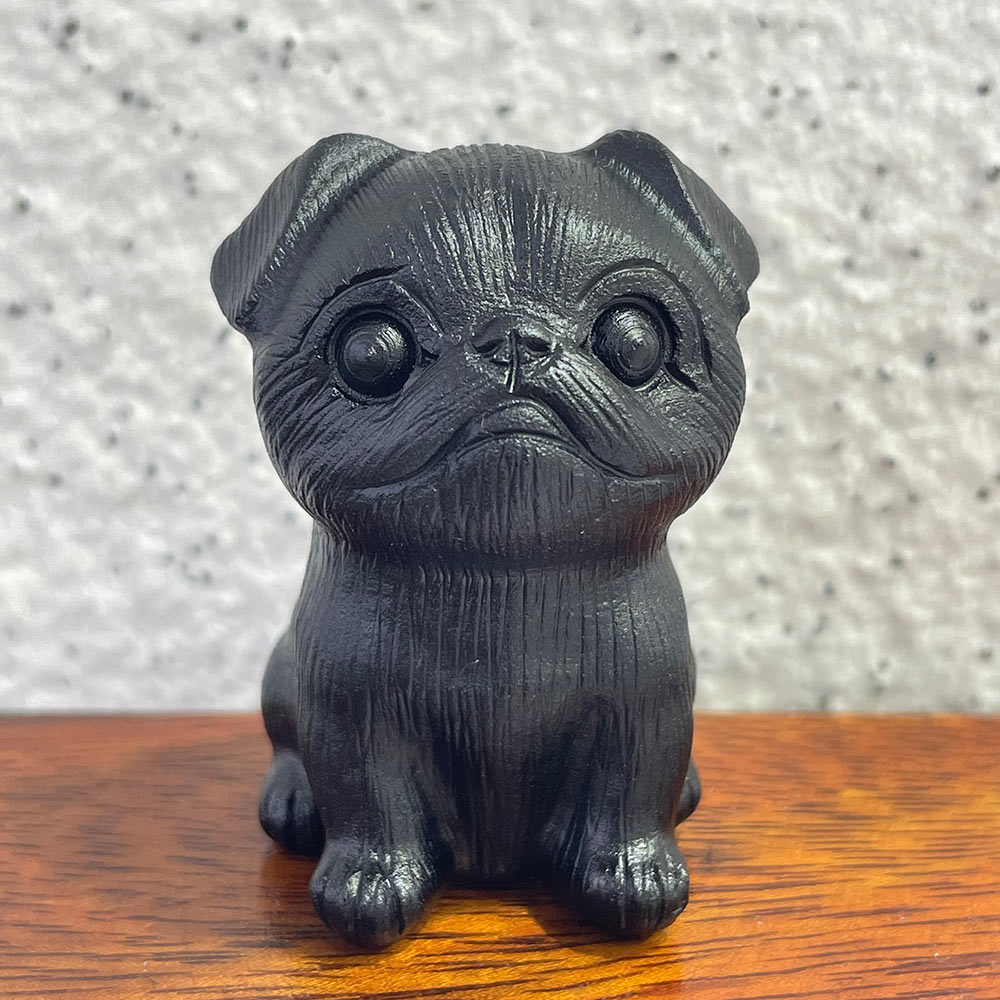 A cute, hand-carved black obsidian Pug dog figurine with big eyes.