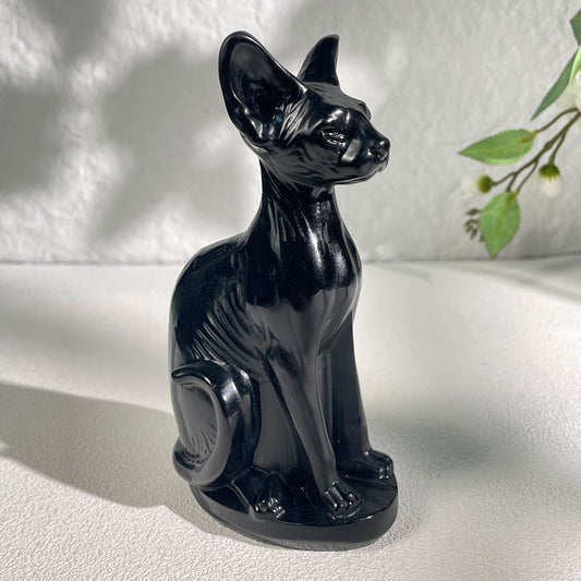 highly polished natural black obsidian crystal carved into a realistic Sphynx hairless cat statue.
