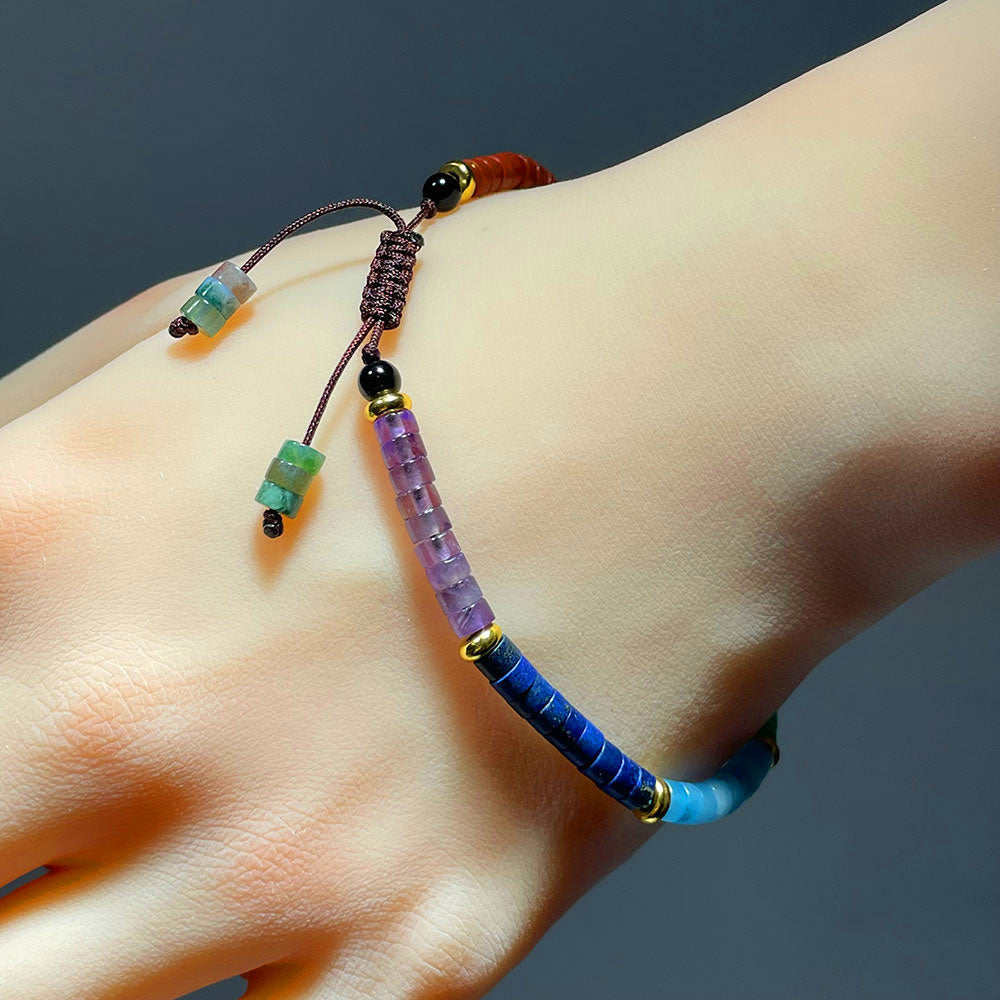 A 7 chakra bracelet being worn on a wrist, showing the adjustable macrame clasp.