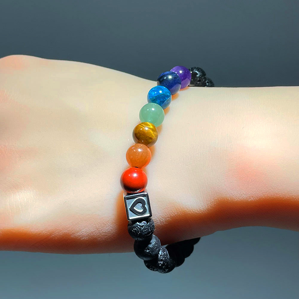 A person wearing the 7 chakra and lava stone stretch bracelet on their wrist