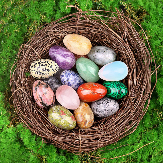 A collection of colorful polished crystal eggs displayed in a decorative bird's nest