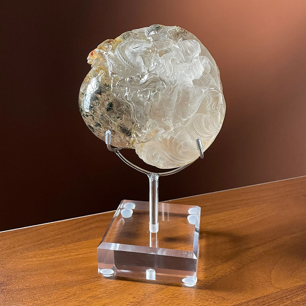 A massive 1.13kg clear quartz crystal featuring a frosted carved Chinese dragon on one side and a clear window showing golden rutile and green phantom inclusions on the other.
