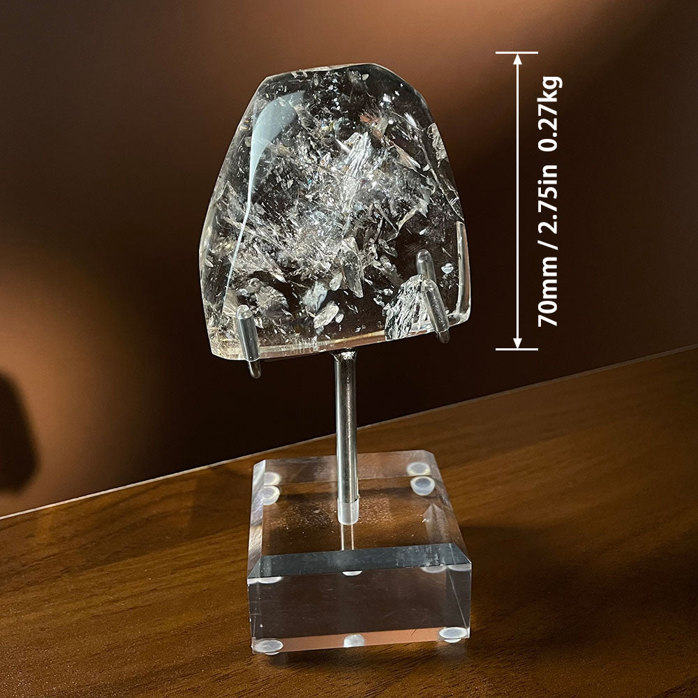 A highly transparent natural Madagascar quartz polished freeform crystal resting on a clear acrylic stand against a dark background.