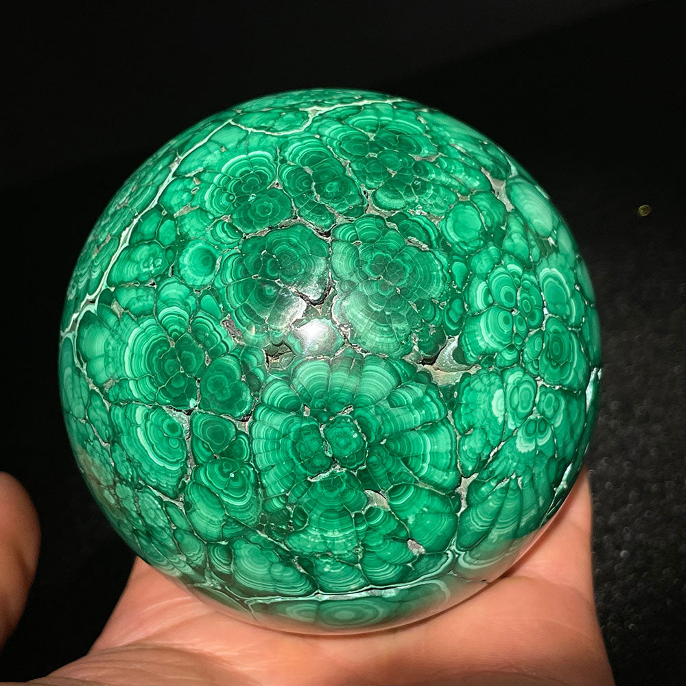 A large 1.19kg genuine natural malachite crystal sphere showcasing vibrant green concentric bullseye patterns against a black background
