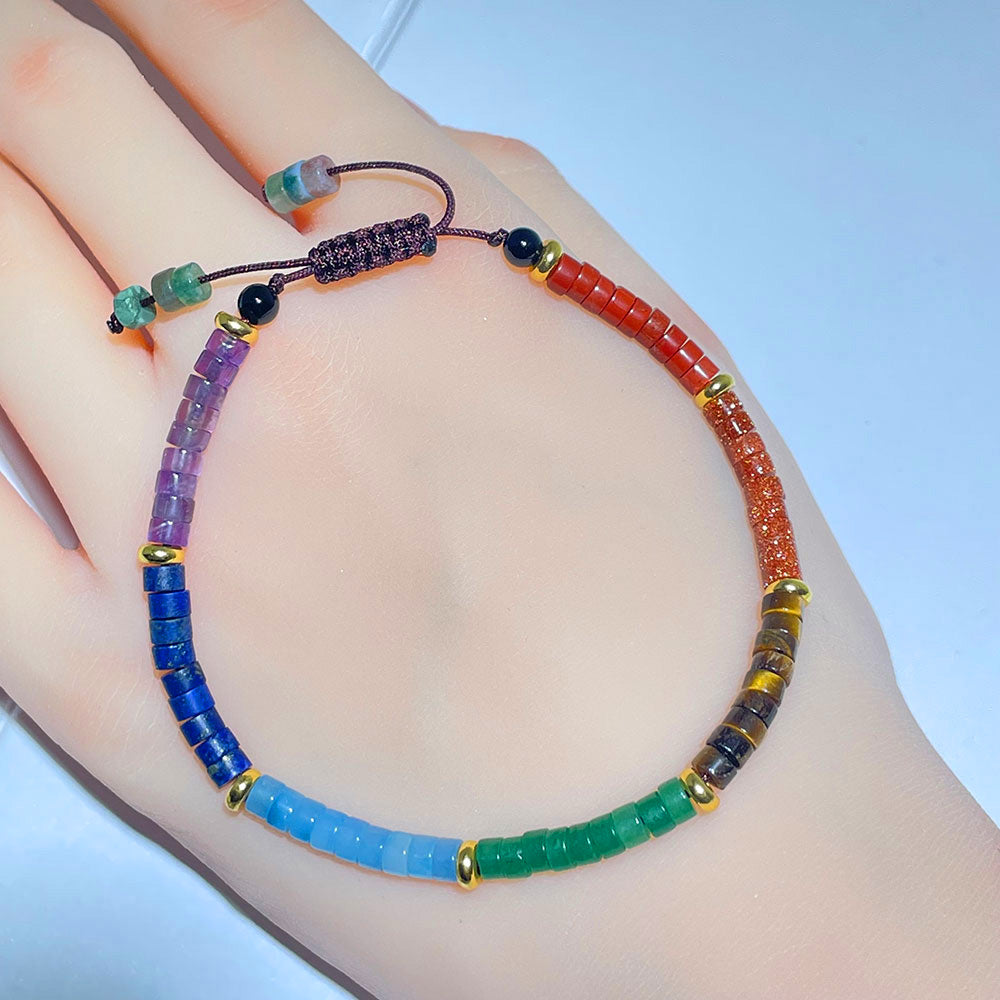 A full view of the colorful 7 chakra gemstone bracelet worn on a person's wrist.