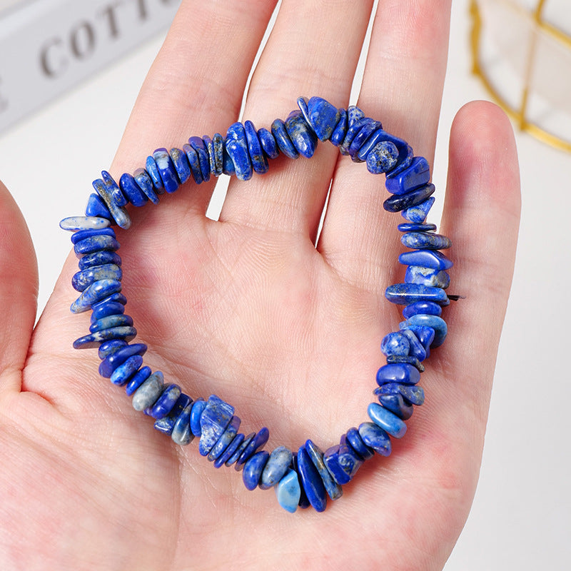 Hand holding a vibrant blue lapis lazuli crystal chip bracelet