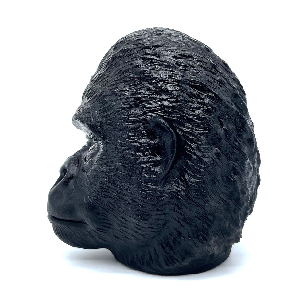 Side profile of a hand-carved black obsidian gorilla statue showing fur texture.