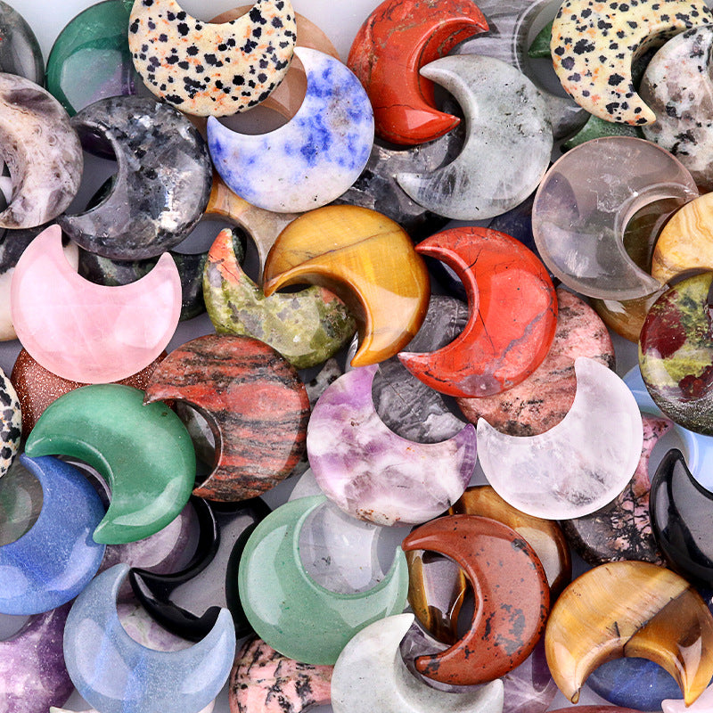 A close-up pile of colorful, polished gemstone crescent moons, showing their variety and texture.