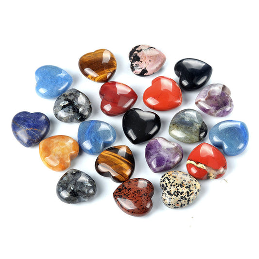 A scatter of various polished gemstone puffy hearts on a white background