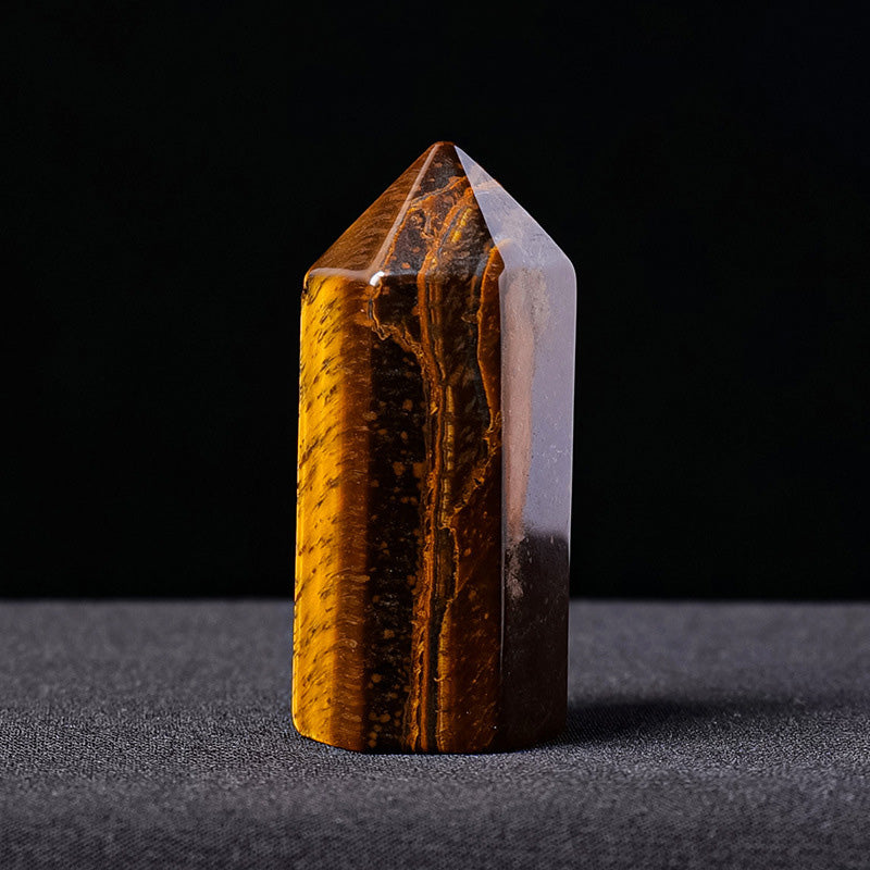A polished mini tiger's eye crystal generator point showing its golden chatoyancy