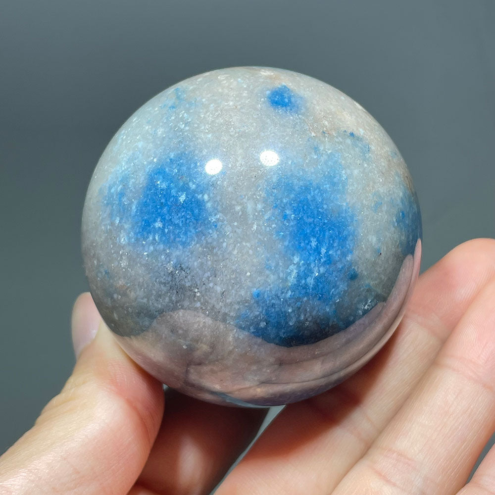 Closeup of a Trolleite crystal ball showing its vibrant blue mineral inclusions.